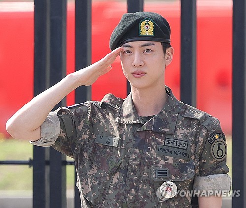 Jin, miembro de BTS, saluda en la 5ª División de Infantería del Ejército en Yeoncheon, a 61 kilómetros al norte de Seúl, el 12 de junio de 2024, tras completar los 18 meses de su servicio militar obligatorio