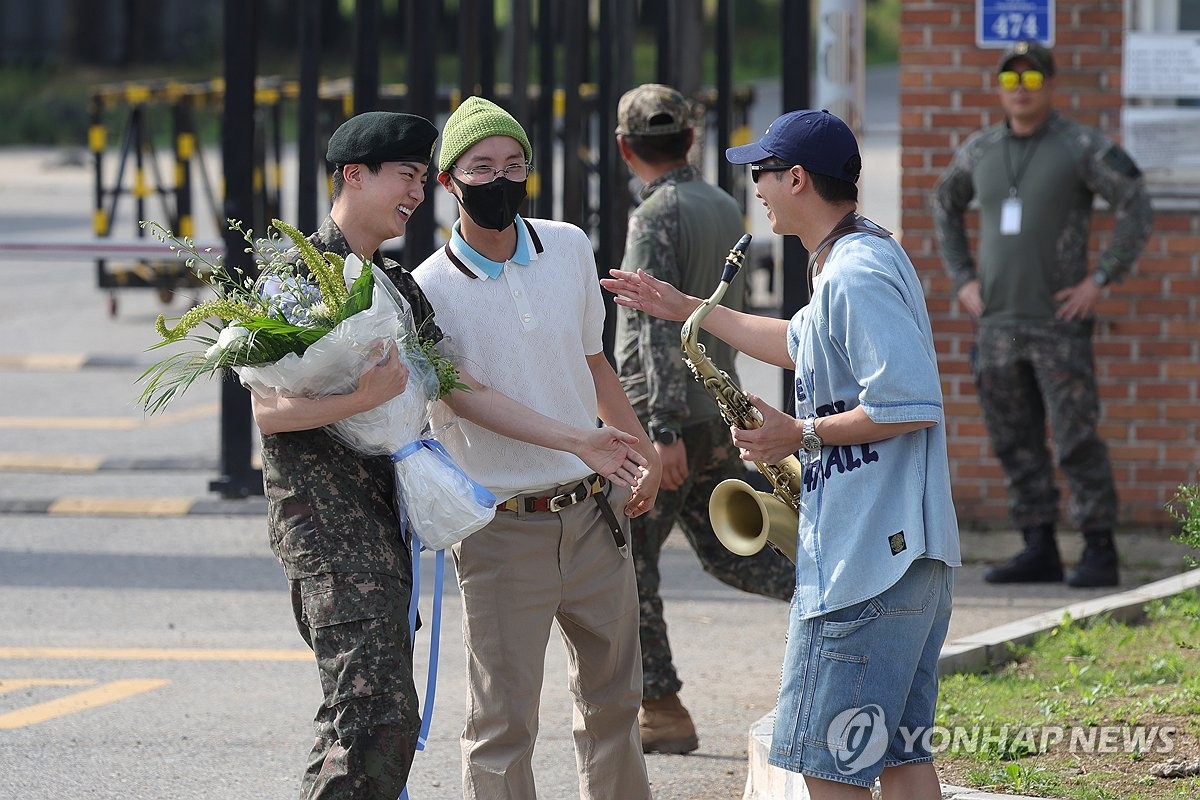 Jin (izda.), miembro de BTS, se reúne y saluda a algunos de sus compañeros de banda, luego de ser licenciado del Ejército, el 12 de junio de 2024, mientras abandona la 5ª División de Infantería del Ejército, en Yeoncheon, a 61 kilómetros al norte de Seúl. 